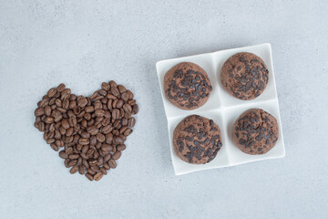 Chocolate cookies with coffee beans on white background