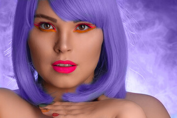 Naklejka premium portrait of a girl with purple hair and bright makeup on a purple background with smoke