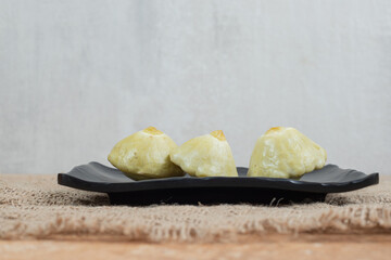 Pickled fruits on black plate with burlap