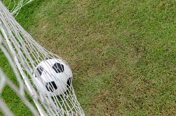 Obraz premium The soccer football with the net on the artificial green grass soccer field