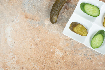 Pickled and fresh cucumber slices on white plate
