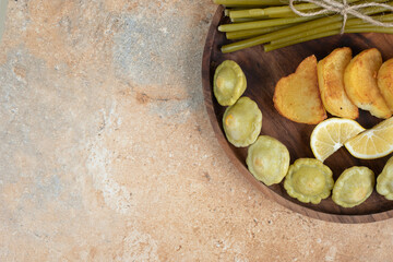 Pickled olives, green beans and fried potatoes on wooden plate