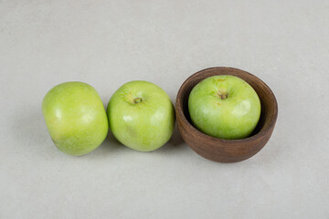Tasty green apples in wooden bowl