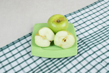 Half cut green apples on green plate