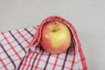 Whole red apple on striped tablecloth