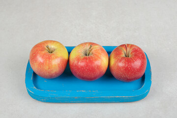 Whole red apples on blue plate