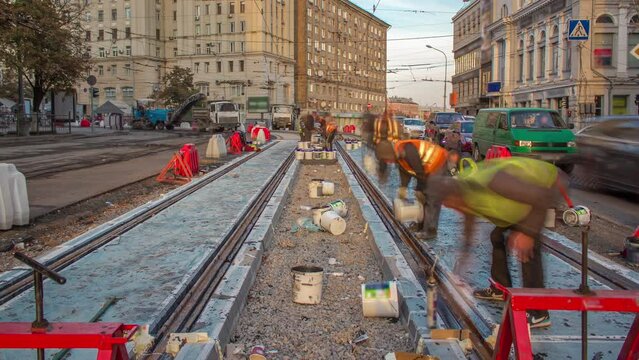 Tram rails at the stage of their installation and integration into concrete plates on the road timelapse. Filling by liquid resin for reduction of vibration and noice. The process of reconstruction of
