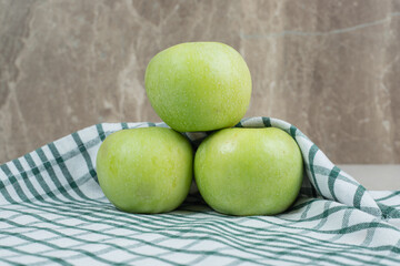Whole green apples on striped tablecloth