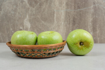 Fresh green apples in wooden basket