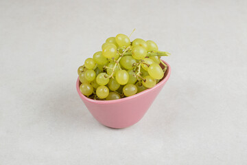 Fresh green grapes in pink bowl
