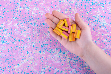 Few chewing gums in a palm on a colorful background