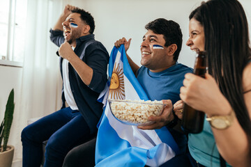 Football fans friends watching Argentina national team in live soccer match on TV at home