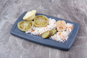 Assortment of homemade pickles on dark plate