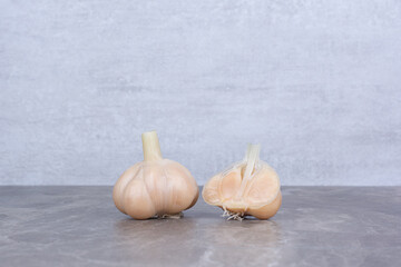 Two pickled garlic on marble background