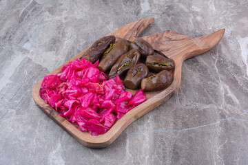 Pickled eggplants and red cabbage on wooden board