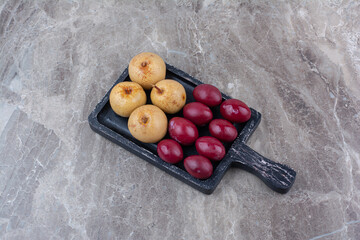 Two kinds of pickled fruits on dark board