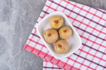 Pickled fruits in white bowl with tablecloth