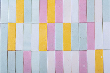 A neatly aligned and colorful arrangement of chewing gums