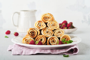Pancakes. Stack of crepes or thin pancakes with berries, with raspberries and honey for breakfast. Homemade breakfast. Copy space. Selective focus.