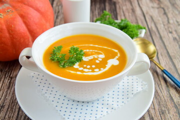 Pumpkin soup with coconut milk with parsley. Wooden background