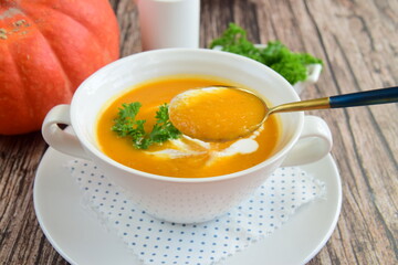 Pumpkin soup with coconut milk with parsley. Wooden background