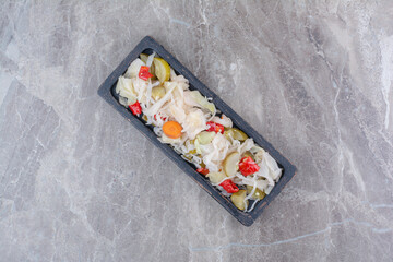 Variety of chopped pickles on dark plate