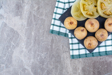 Various pickled vegetables and fruits on dark board