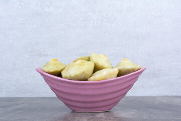 Various pickled fruits in pink bowl