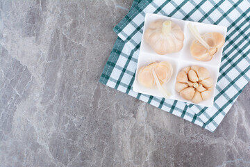 Tasty pickled garlic on white plate