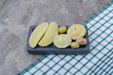 Various pickled vegetables on dark plate