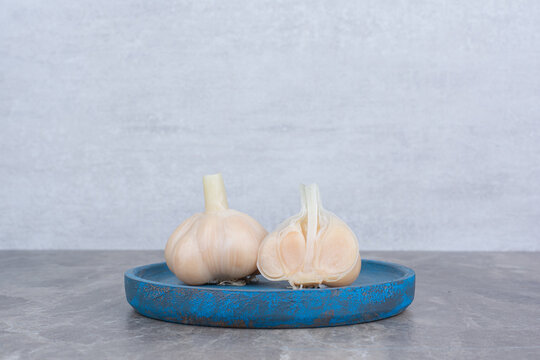 Tasty pickled garlic on blue plate