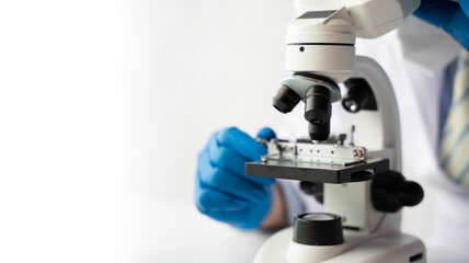 Scientist working at the laboratory, doctor looking at a test tube of clear solution in a laboratory.