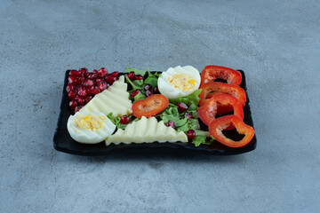 Assorted breakfast set on a black platter on marble background