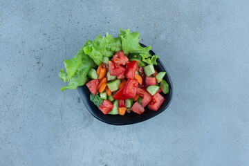 A bowl of shepherd's salad on marble background