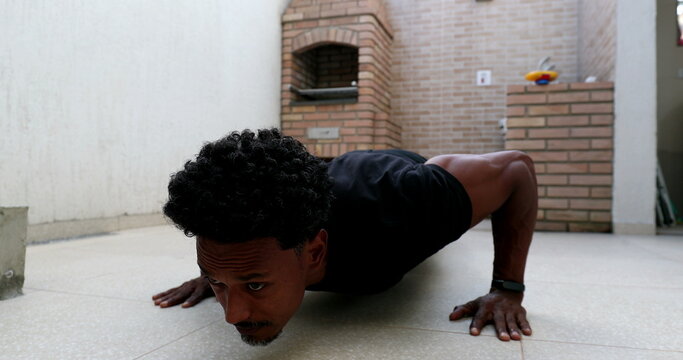 African man doing push up at home