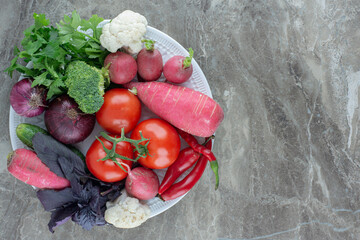 Healthy platter of cauliflower, turnip, pepper, tomato, broccoli, amaranth and coriander on marble...