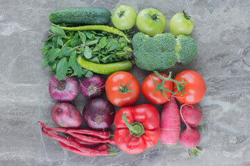 Neatly arranged bundle of vegetables on marble background