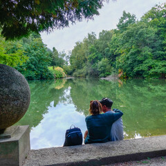 Couple d'amoureux assis devant un étang
