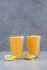 Two glasses of beer with fish and sliced lemon