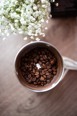 Brown coffee beens in coffee grinder on the wood table