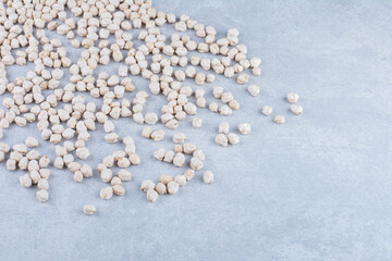 Small pile of chickpeas scattered about on marble background