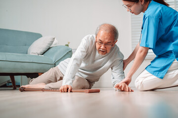Asian caregiver helping senior male from falling on the ground. Older elderly man patient having accident heart attack when physical therapy. Nurse assistance rescue concept.