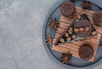 A dark cutting board of sweet cake and star anise