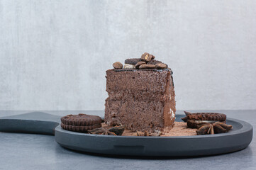 A dark cutting board of sweet cake and star anise