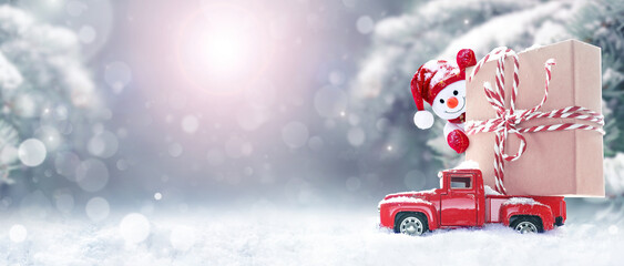 Christmas background with snow, snowman and retro red car with gift box. .Merry Christmas and happy...