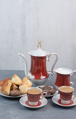 Two cups of aroma coffee with pastries on gray background