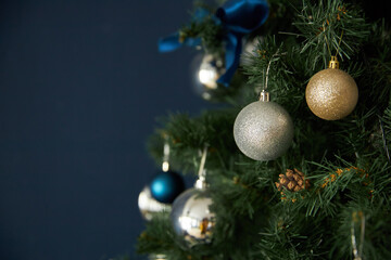 Christmas toys balls hang on fir branches, on a blue background
