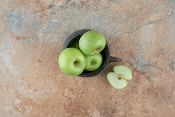 A fresh apples with an ancient cup on marble background