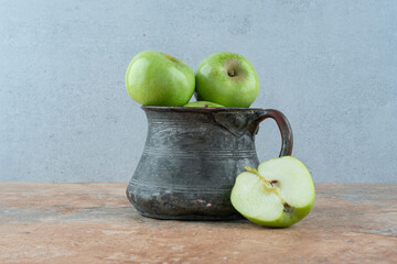 A fresh apples with an ancient cup on marble background