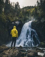 Hiker standing close to Waterfall in Austria - Gollinger Waterfall during Autumn
 - obrazy, fototapety, plakaty